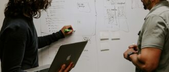 man wearing gray polo shirt beside dry-erase board