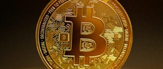 a golden bitcoin sitting on top of a table