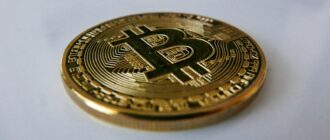 a gold bit coin sitting on top of a white table